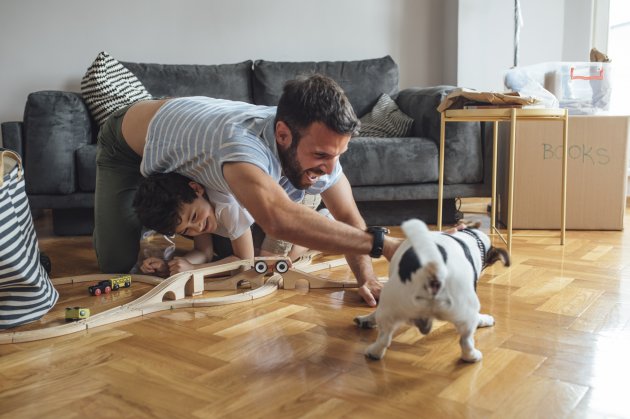 father and son playinng with dog